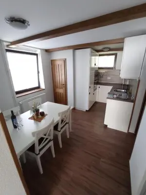a kitchen and dining room with a white table and chairs at Private house near Terme Čatež in Cerklje ob Krki