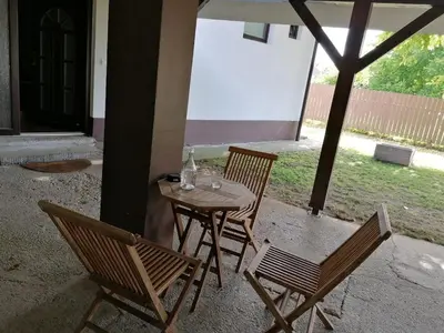 a table with two chairs and a table with a bottle on it at Private house near Terme Čatež in Cerklje ob Krki