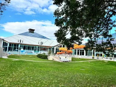 a large building with a swimming pool in a park at Oddam hiško Lipa Čatež - Čateške Toplice in Brežice