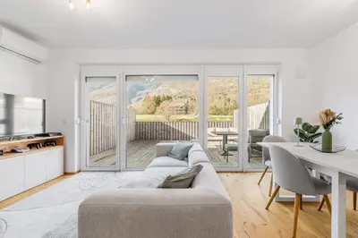 a white living room with a couch and a table at Family Apartment Bovec in Bovec