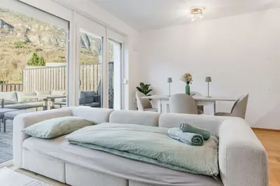 a white living room with a couch and a table at Family Apartment Bovec in Bovec