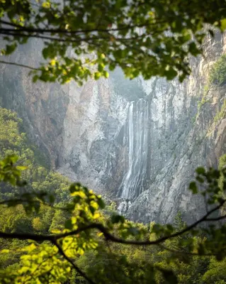 a waterfall on the side of a cliff at Family Apartment Bovec in Bovec