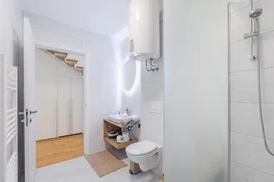 a white bathroom with a toilet and a sink at Family Apartment Bovec in Bovec
