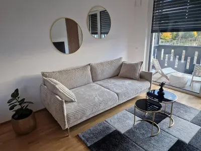 a living room with a couch and a mirror at Apartments Ana in Maribor