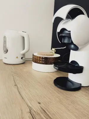 a coffee maker and a toaster on a wooden floor at Apartments Ana in Maribor