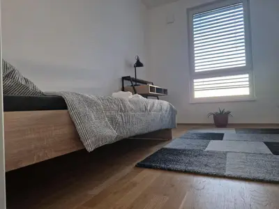 a bedroom with a bed and a window and a rug at Apartments Ana in Maribor