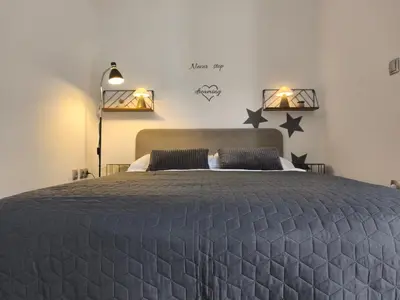 a bedroom with a bed with black stars on the wall at Apartma Ariana in Loče pri Poljčanah