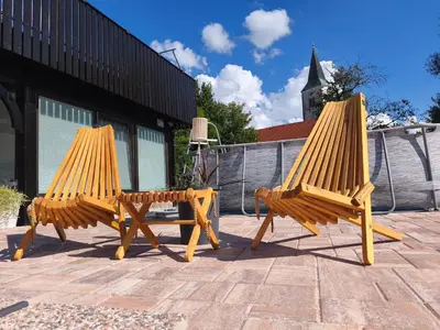 two wooden chairs and a table on a patio at Apartma Ariana in Loče pri Poljčanah