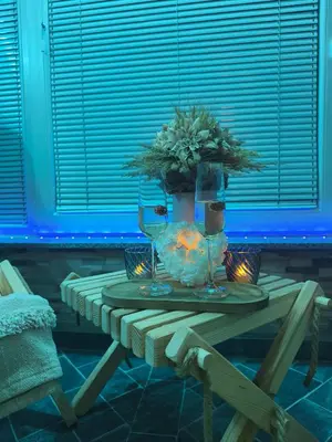 a table with a vase with a christmas tree and candles at Apartma Ariana in Loče pri Poljčanah