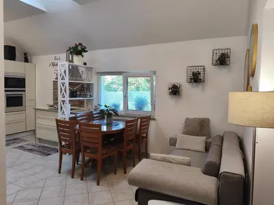 a kitchen and dining room with a table and a couch at Apartma Ariana in Loče pri Poljčanah