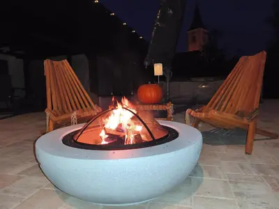 a fire pit with two chairs and a pumpkin at Apartma Ariana in Loče pri Poljčanah