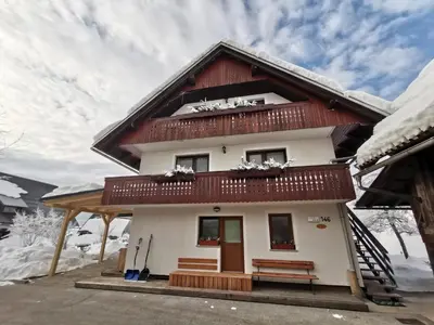 a house with snow on the roof at Apartment Jakovc in Bohinj