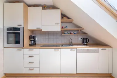 a kitchen with white cabinets and a sink at Apartment Jakovc in Bohinj