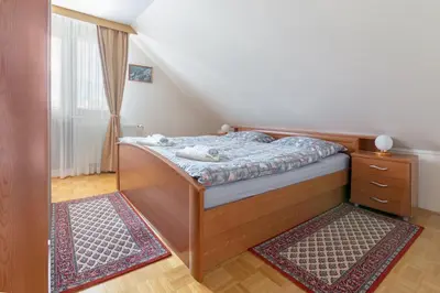 a small bedroom with a bed and a dresser at Apartment Jakovc in Bohinj