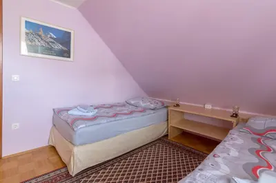 a small bedroom with a bed and a table at Apartment Jakovc in Bohinj