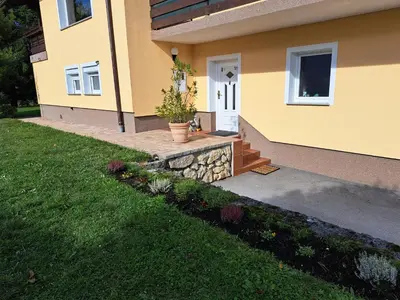 a yellow house with a white door and a porch at Apartma Gašper in Šentjur
