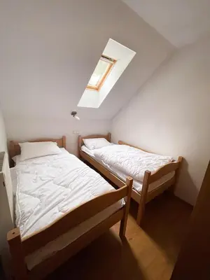 two beds in a small room with a skylight at Apartment Rogla Residence in Vitanje