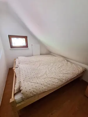 a small bed in a room with a window at Apartment Rogla Residence in Vitanje
