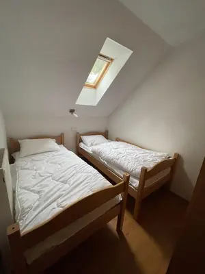 two beds in a small room with a skylight at Apartment Rogla Residence in Vitanje