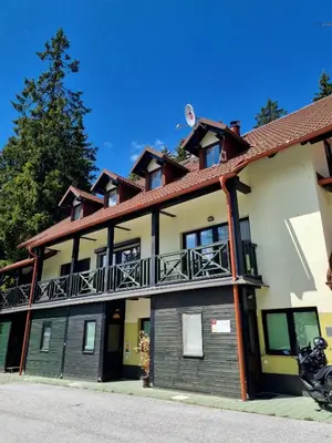 a building with a motorcycle parked in front of it at Apartment Rogla Residence in Vitanje