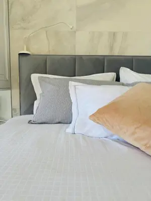 a bed with white sheets and pillows on it at Vila Brinje Private room with spa in Dol pri Ljubljani