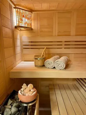 a sauna with towels on a wooden shelf at Vila Brinje Private room with spa in Dol pri Ljubljani