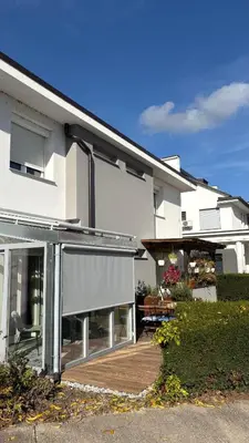 a large white house with a deck and a patio at Studio apartma Rimljanka in Ptuj