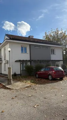 a red car parked in front of a house at Studio apartma Rimljanka in Ptuj