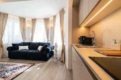 a living room with a blue couch in a kitchen at Beatrice - Boutique Apartments Resort in Ljubljana