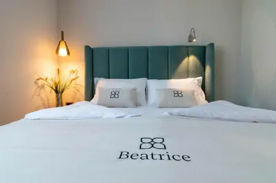 a bed with a green headboard and two pillows on it at Beatrice - Boutique Apartments Resort in Ljubljana