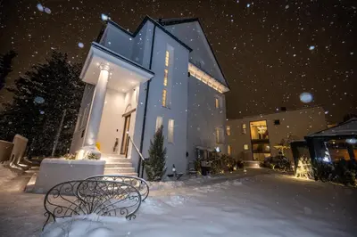 a blue building with two benches in the snow at Beatrice - Boutique Apartments Resort in Ljubljana