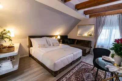 a bedroom with a large white bed and a couch at Beatrice - Boutique Apartments Resort in Ljubljana