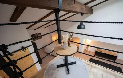 an attic room with a table and some ropes at Horse Whispering Ranch apartma in Ilirska Bistrica