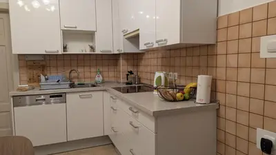 a kitchen with white cabinets and a bowl of fruit on the counter at Cozy rooms in the center of Bled by the lake #1 in Bled