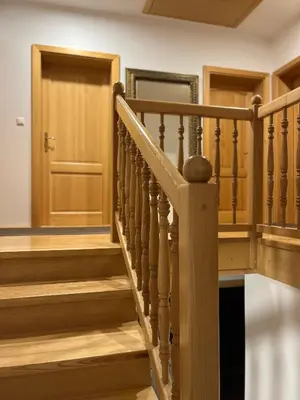 a wooden staircase with a wooden door in a house at Pr Fajfarju in Spodnja Sorica