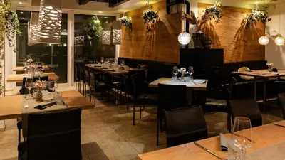 a restaurant with wooden tables and chairs and lights at Oaza Luxury Glamping Resort in Moravske Toplice