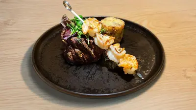 a black plate with food on a wooden table at Oaza Luxury Glamping Resort in Moravske Toplice