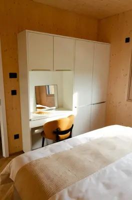 a bedroom with a bed and a desk and a chair at Oaza Luxury Glamping Resort in Moravske Toplice