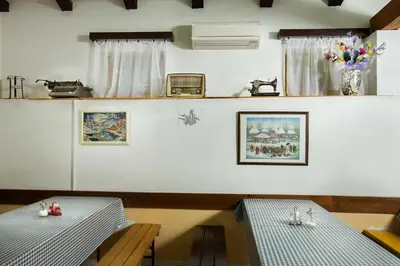 a dining room with two tables and a vase of flowers at Farm Stay Ferjančič in Vipava