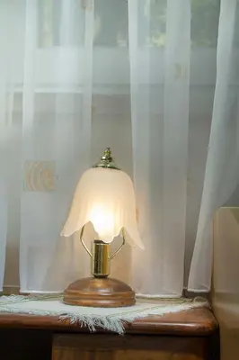a lamp sitting on a table next to a window at Farm Stay Ferjančič in Vipava
