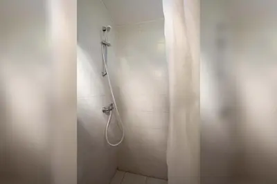 a shower with a shower curtain in a bathroom at Farm Stay Ferjančič in Vipava