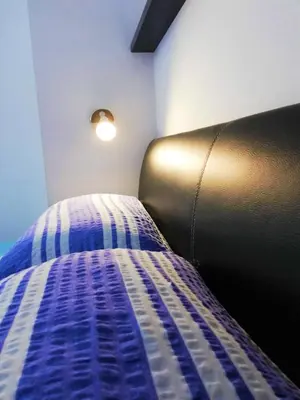 a bedroom with a bed with a blue and white comforter at Dimora Apartments with free parking in Ljubljana