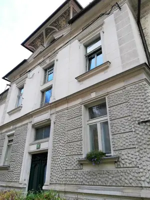a white brick building with windows and a door at Dimora Apartments with free parking in Ljubljana