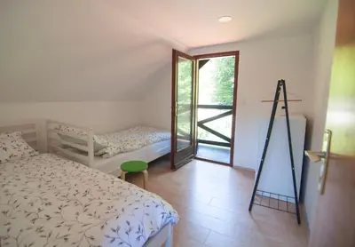 a bedroom with a bed and a window with a ladder at Grunthouse in Prebold
