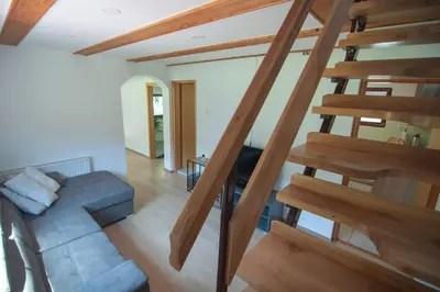 a living room with wooden stairs and a blue couch at Grunthouse in Prebold