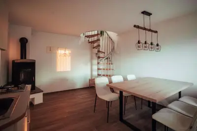 a kitchen and dining room with a wooden table and chairs at SkyView Dežno in Makole