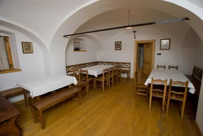 a room with several tables and chairs with white beds at Farm Soržev mlin in Nova Cerkev