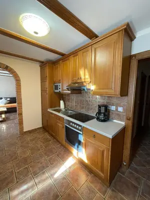 a kitchen with wooden cabinets and a stove top oven at APARTMA ARNIKA Rogla, Turistično naselje NUNE RESNIK, RESNIK 110 in Zreče