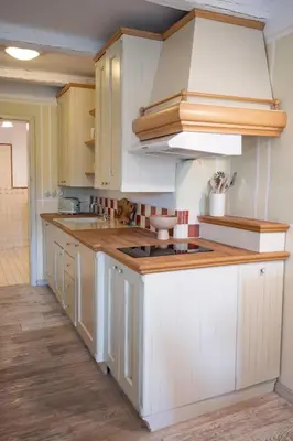 a kitchen with white cabinets and wooden counter tops at Apartmaji Hiša kranjske čebele in Višnja Gora