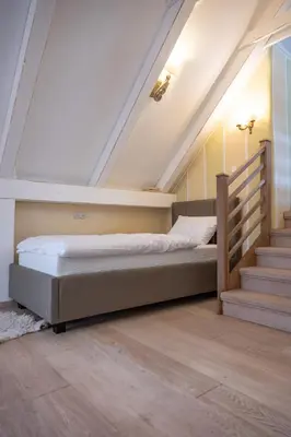 a bedroom with a bed and a staircase at Apartmaji Hiša kranjske čebele in Višnja Gora